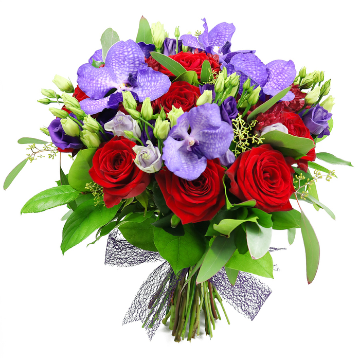 An opulent hand-tied bouquet dominates the frame, a luxurious blend of deep red roses and striking purple Vanda orchids, their broad petals presenting a regal, bejeweled texture. The velvety red blooms form a warm heart, while the orchids add an exotic note with speckled lavender tones that glow as light passes through. Interspersed are clusters of smaller eustoma, their soft lilac blossoms and neatly closed buds lending air and elegance to the arrangement. The greenery is abundant and varied: large glossy dark-green leaves provide a rich backdrop, while slender stems and unopened buds punctuate the design with fresh vitality. The stems are gathered at the base and secured with a dark, near-black mesh ribbon, giving the piece a contemporary edge and a tactile, woven finish. This generous bouquet radiates romance, celebration, and refined taste, making it a perfect gift for anniversaries, Valentine's Day, or as a lavish centerpiece for a table in a Yiewsley home or local venue. It speaks to a craftsman's eye for balance and texture, inviting the viewer to linger on the contrasts between bold colour and soft, architectural greenery. A reminder that flowers, carefully chosen and expertly tied, can transform a room and lift a moment in any corner of the area.