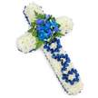 A traditional Christian cross made from fresh flowers is displayed horizontally on a seamless white background, its design simple, striking, and filled with meaning. The entire shape of the cross is covered with small white spray chrysanthemums, each bloom fresh and fully open, creating a thick, even layer of petals that looks pillowy to the eye and suggests softness to the touch. Around the edge, a royal blue satin ribbon traces the outline, its smooth, lustrous surface folded with precision to hug every curve and corner, giving the arrangement a finished, formal appearance. At the centre of the cross, a focal spray of rich blue blooms rises gently from the white base: full, frilled blue carnations mingle with slimmer blue flowers resembling delphiniums or orchids, all framed by arching fern fronds and deep green foliage that break up the cooler tones with a touch of woodland warmth. Running down the vertical stem, the word DAD has been carefully fashioned from the same blue ribbon, each letter looped and secured so it appears neatly written across the chrysanthemum cushion. The combination of pure white and dignified blue conveys a mood of respect and quiet strength, the sort of tribute families in Yiewsley might choose when arranging a funeral at a nearby church or crematorium. The lighting is gentle and diffused, with barely any harsh shadow, allowing the colours to remain true and the textures of satin, petal, and leaf to be clearly visible, capturing the care and craftsmanship that go into creating a personal farewell for a beloved father.