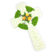 A long, three-dimensional Celtic cross crafted entirely from fresh flowers, photographed against a bright, clean white background and viewed from just above so you can read its full form. The arms and shaft are densely covered in pure white spray chrysanthemums, their small petals creating a soft, plush surface that reads as both pure and peaceful. Interlaced through the white are cushions of bright apple-green button chrysanthemums that trace the circular ring at the cross's centre and fill alternating segments of each arm, producing the gentle rhythm of a Celtic knot in living colour. At the exact meeting point of the arms a trio of rich orange roses forms a warm, poignant focal point; their golden-orange petals are fully opened and seem to glow against the crisp whites and greens, while a few dark green fern sprigs cradle them, lending depth and a cool, leafy contrast. The arrangement's texture-velvety chrysanthemum clusters, tight button blooms, and the smooth, velour petals of the roses-is emphasized by soft, even lighting that picks out petal edges and shadowed relief. The overall effect is dignified and intimate, a sympathy or funeral tribute that quietly honours Celtic heritage and Irish connections without being ornate. As a local florist familiar with Yiewsley's community, I imagine this placed near a church service on the High Street or at a graveside service around Colham Green, radiating calm, remembrance, and a subtle hint of hope in its warm central roses.