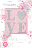 This anniversary card is a tender celebration of enduring romance, its design unfolding in soft pastel pinks and cool silvery greys that echo the muted tones of a peaceful Yiewsley evening. At the centre sits the word LOVE, each letter softly raised and edged with fine glitter, with the O transformed into a shimmering silver heart textured enough to feel under your fingers. This heart glows slightly brighter than the surrounding letters, like a focal bloom in a carefully composed bouquet. Around it, delicate blossoms in blush and mauve unfurl across the card with a watercolour gentleness, their edges soft and slightly blurred, as if brushed onto the paper in light strokes. Flowing lines curl into vines and stems, giving the impression of a romantic English spring garden, the kind you might imagine beyond the houses and side streets near Yiewsley's shops. Tiny flourishes-small petals, airy swirls, and subtle butterfly silhouettes-add a sense of motion, suggesting petals caught on a light breeze. The phrases On Our Anniversary and I love you today and always are written in an elegant, understated script, balanced carefully so as not to crowd the floral artwork. The composition feels like a moment of stillness and gratitude: a keepsake card that pairs perfectly with an anniversary bouquet arriving at a doorstep in Yiewsley, softly whispering how far two hearts have travelled together and how deeply they remain entwined.